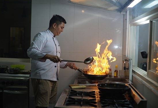 restaurant chef cooking over an open flame